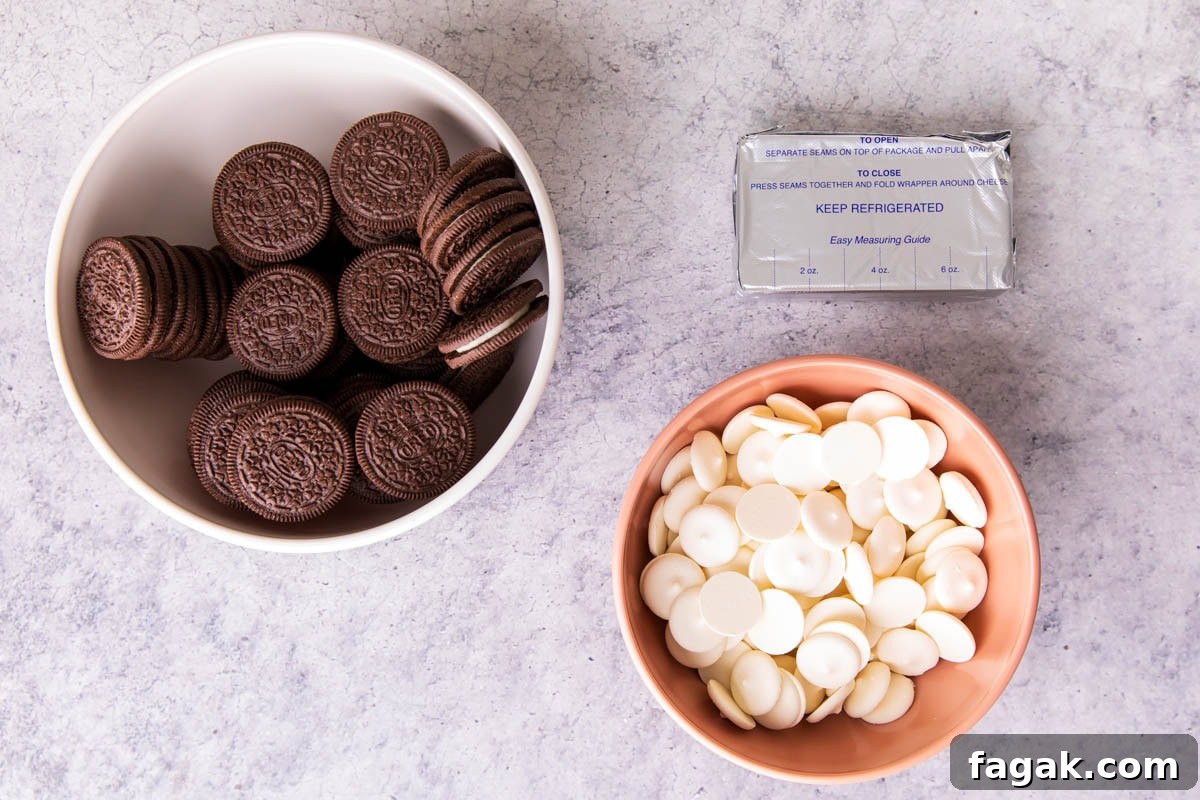 Showing Oreo truffles 3 ingredients on a table including Oreo cookies, white chocolate candy melts, and cream cheese.