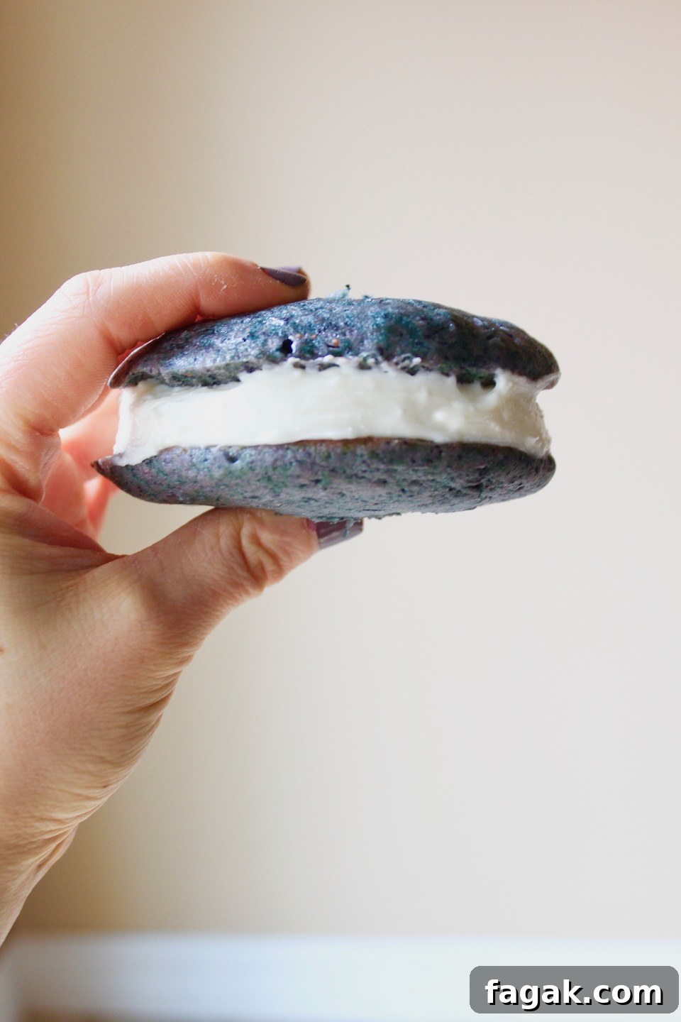Hand holding blueberry whoopie pie