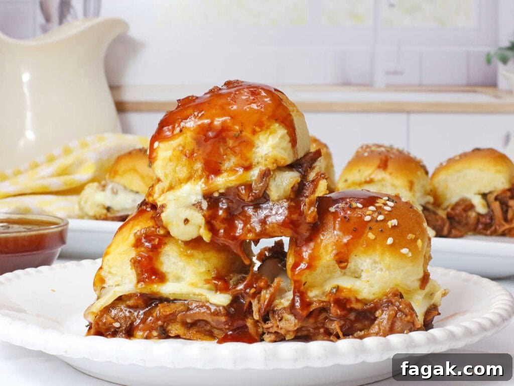 BBQ Brisket Sliders Made from Leftover Beef Brisket 9 Three leftover brisket sliders with barbecue sauce on a white plate with more sandwiches in the background.