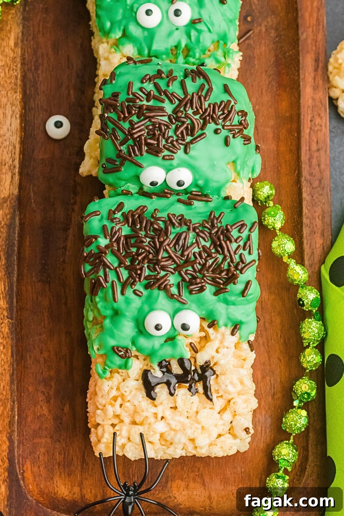Fun Halloween rice krispies treats in the shape of Frankenstein on a wooden board.