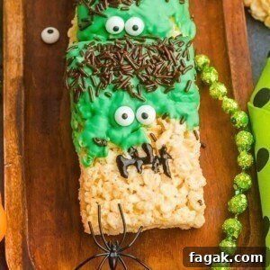 Decorated Frankenstein rice krispies treats on a wooden board.