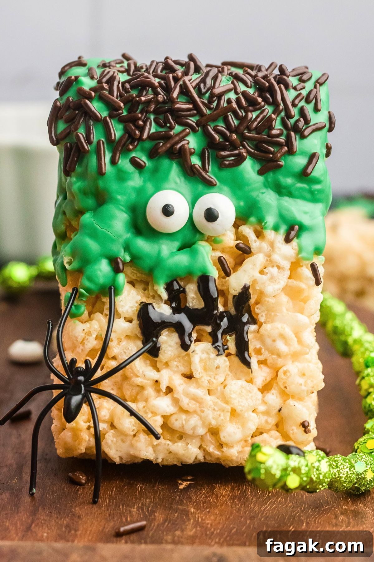 Close up of Rice krispie treat decorated to look like Frankenstein on a wooden board.