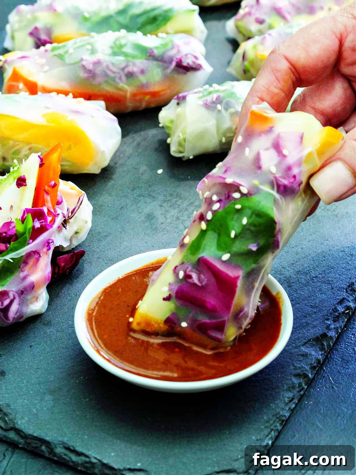 Crispy Vegetable Spring Rolls Recipe with Dipping Sauce 7 Spring rolls with ginger dipping sauce and a person dipping one into the sauce