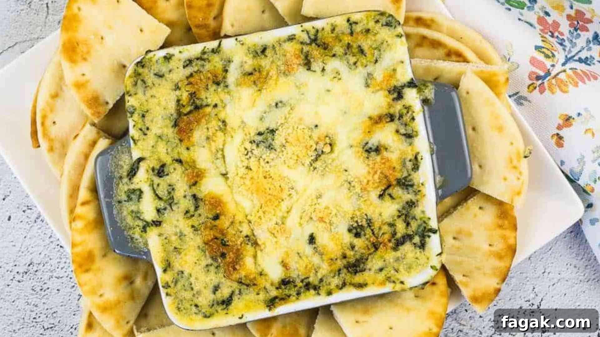 Spinach & Brie Dip in a casserole dish surrounded by pita wedges.