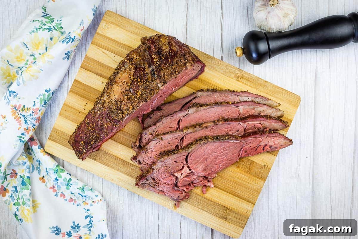 Sliced smoked ribeye beef on a cutting board.
