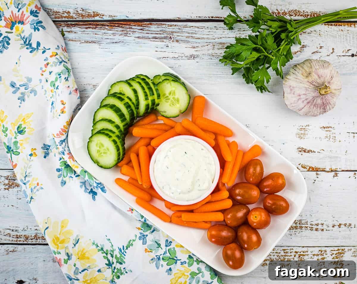 A plate with carrots, cucumbers and garlic dip.