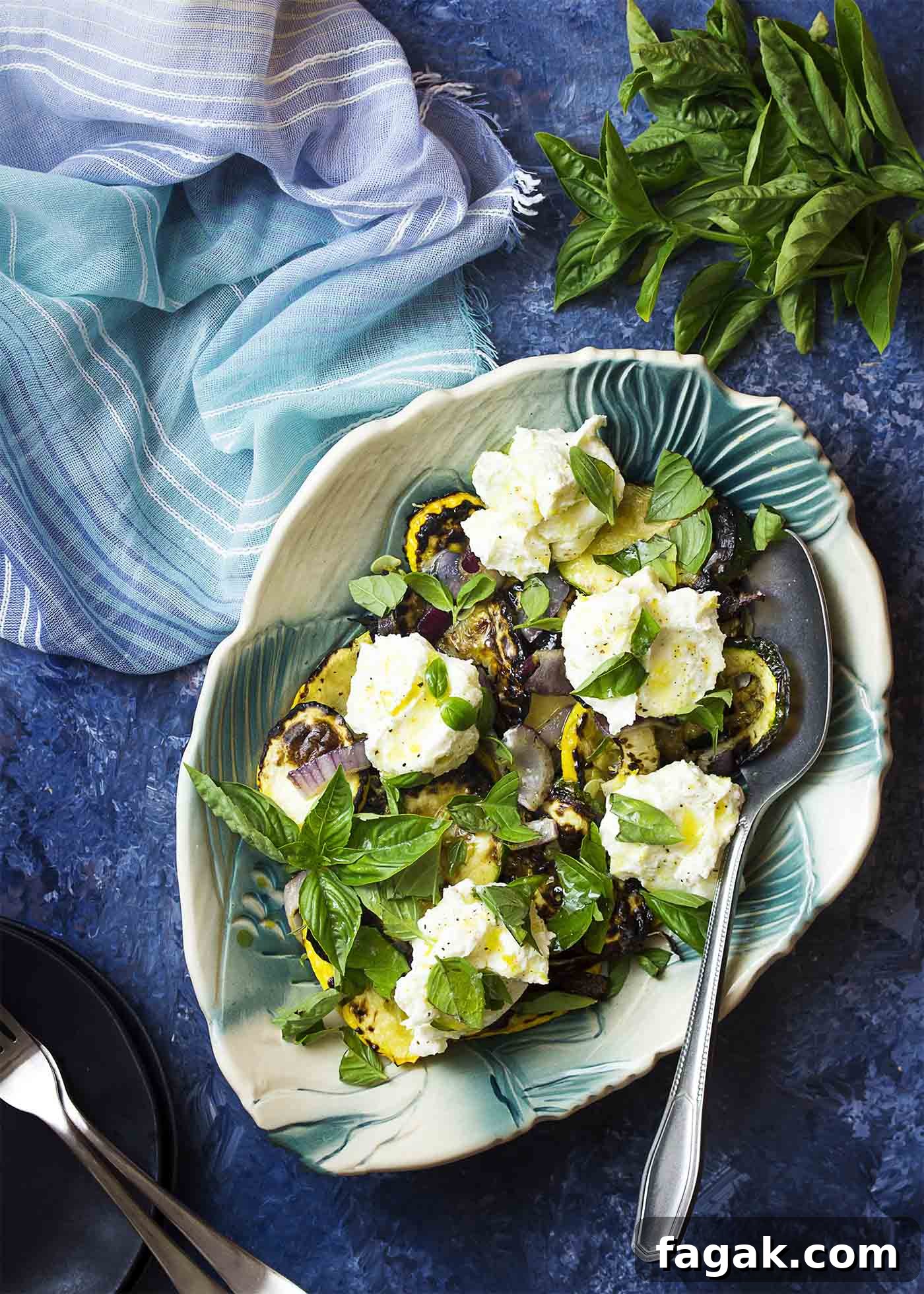 Serving dish of grilled zucchini salad with lemon ricotta and fresh basil over the top.