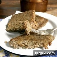 a white plate of scrapple with two slices on the plate and another part slice, fork holding piece