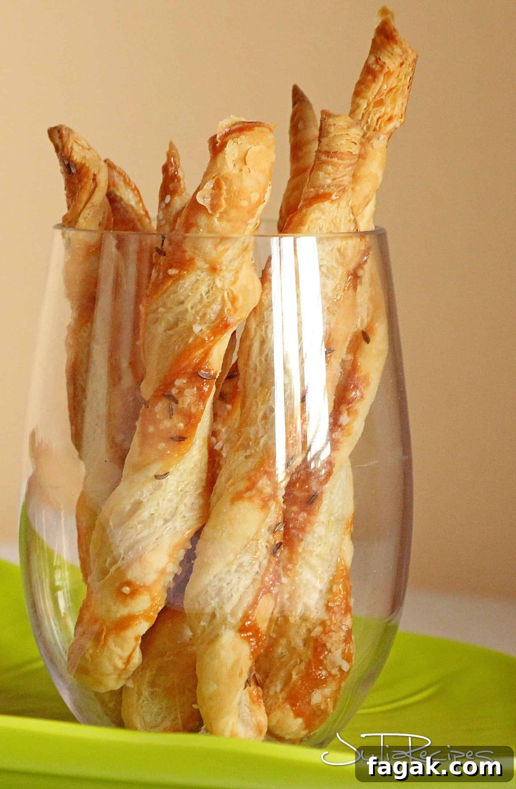 puff pastry sticks with parmesan in wine glass on green platter