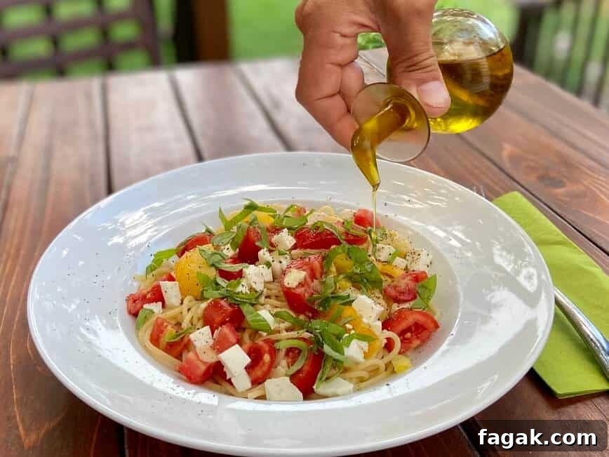 Fresh Tomato, Basil & Mozzarella Pasta Recipe for Summer 8 Pouring olive oil over finished pasta.