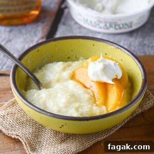 Creamy polenta in a yellow bowl with peaches and mascarpone.