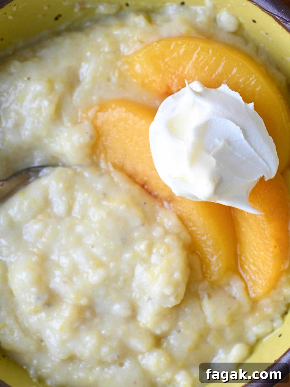 Overhead of creamy polenta with peaches and cream in a bowl.