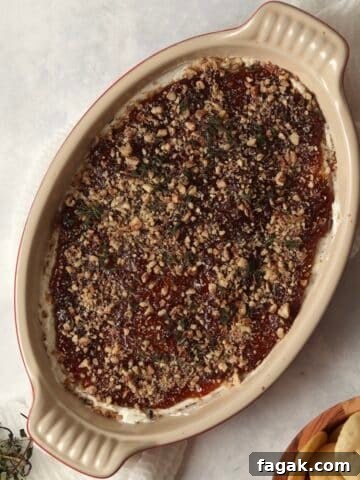 Goat Cheese and Fig Dip in a dish topped with thyme and pecans.