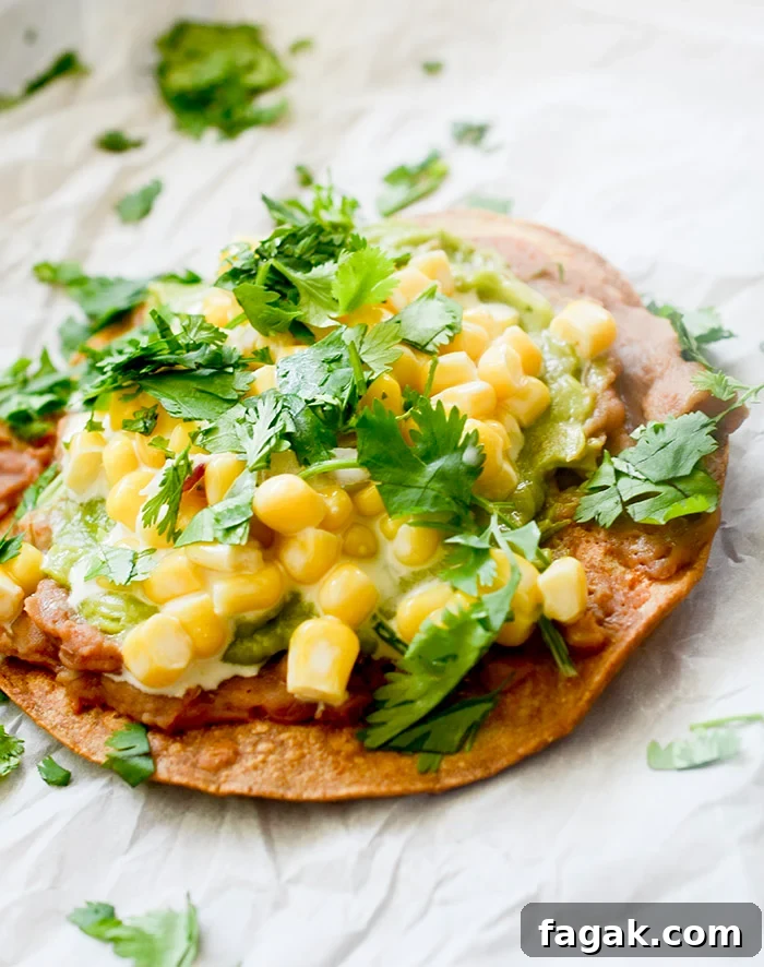 Corn tostadas topped with refried beans, guacamole, and Mexican street corn.