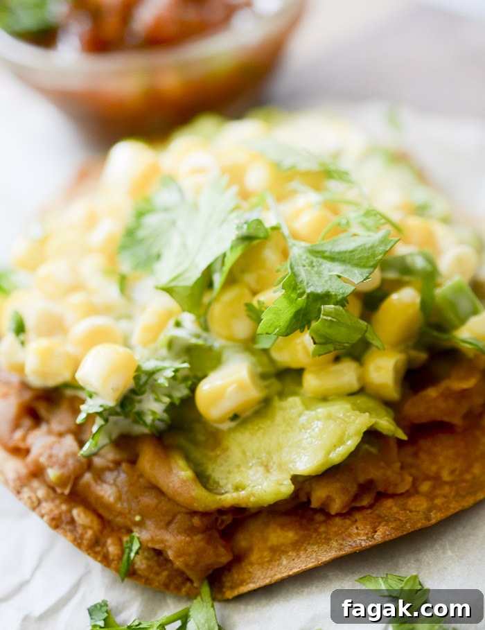 Corn tostadas topped with refried beans, guacamole, and Mexican street corn.