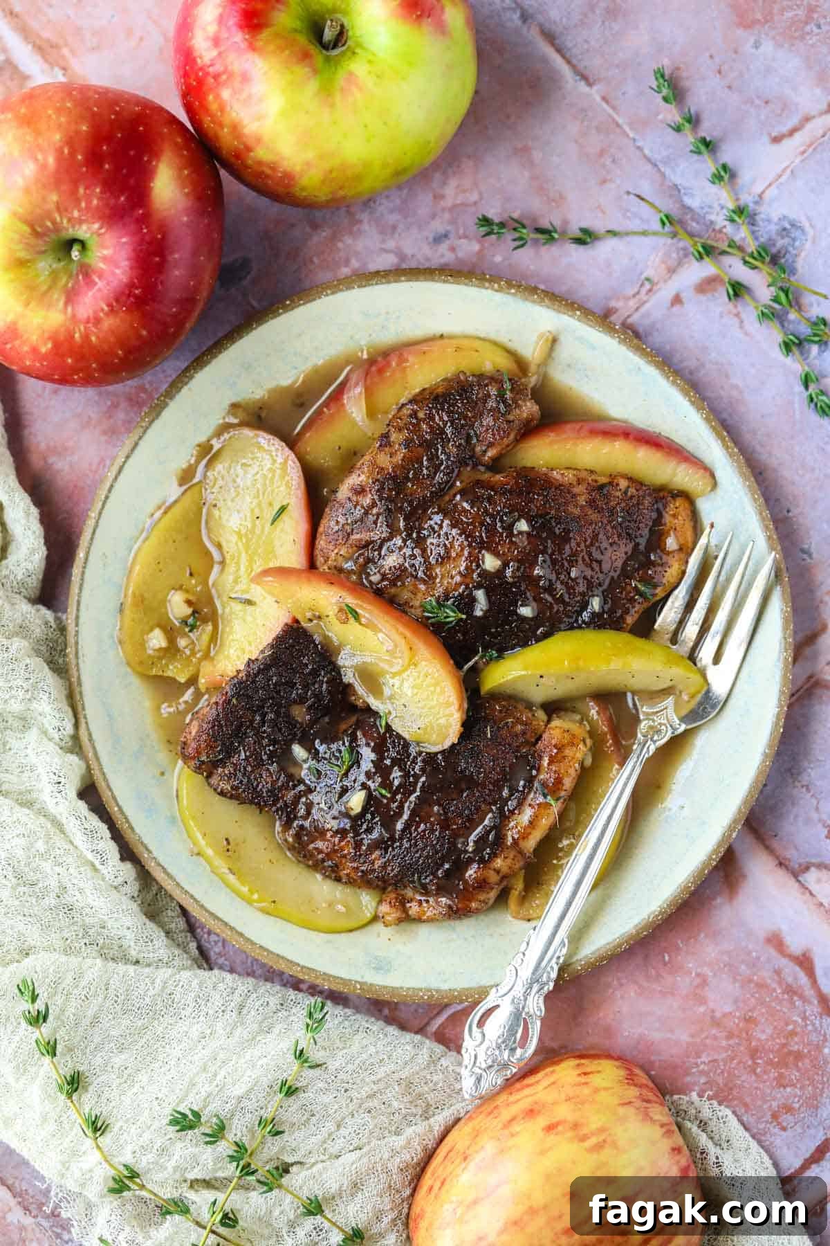 apple cider chicken on a gray plate with a silver fork.