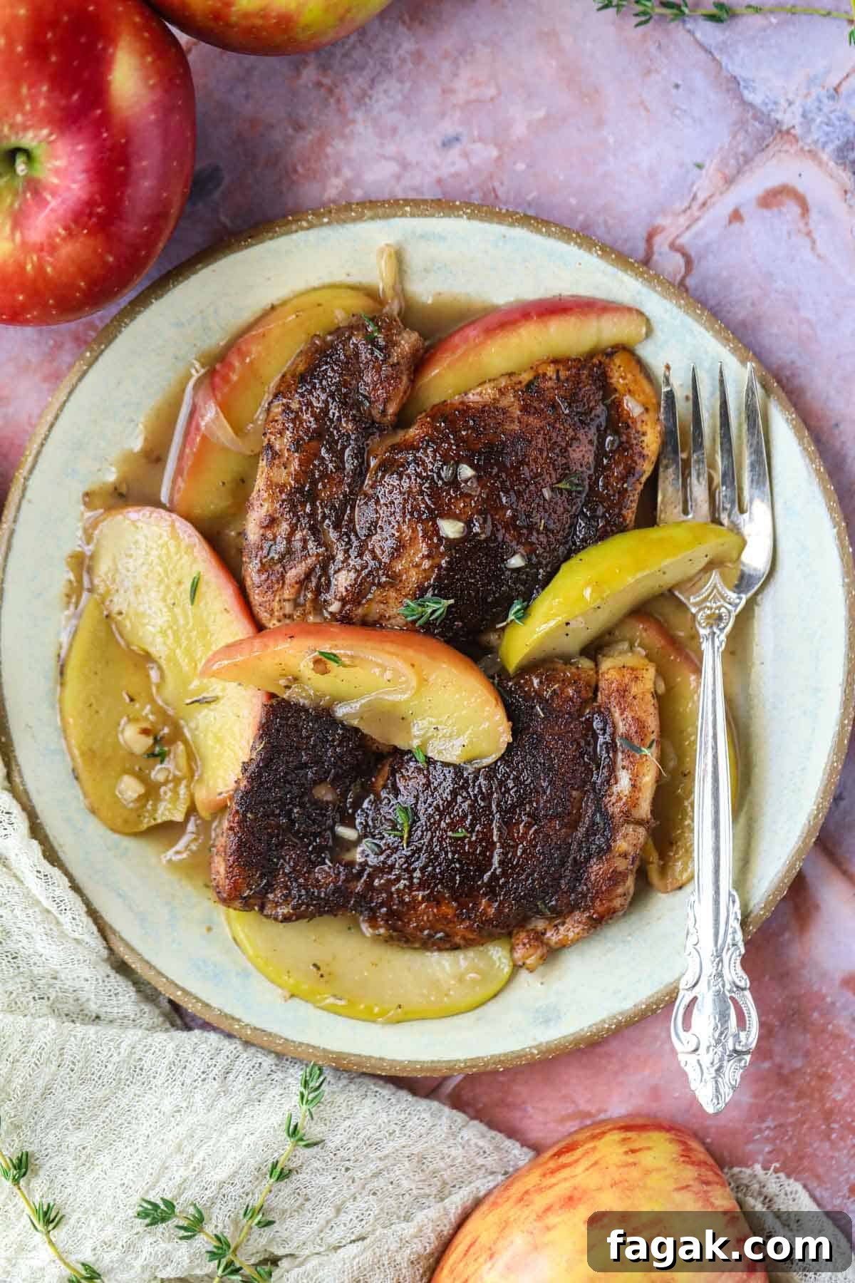 apple cider chicken on a gray plate with a silver fork.