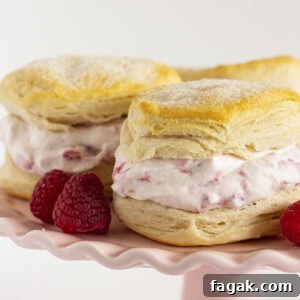Raspberry shortcake on a pink cake plate with fresh raspberries.