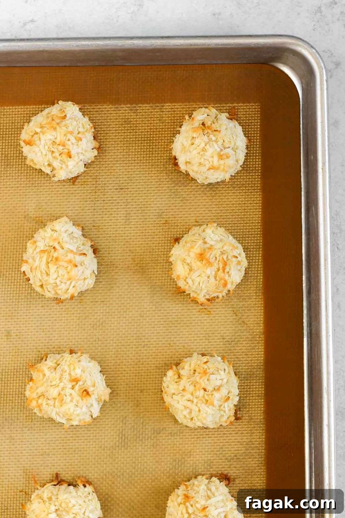 Baked coconut macaroons on a cookie sheet.