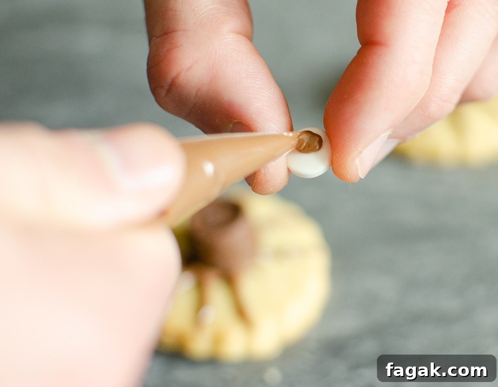 Sticking on edible eyes with melted chocolate
