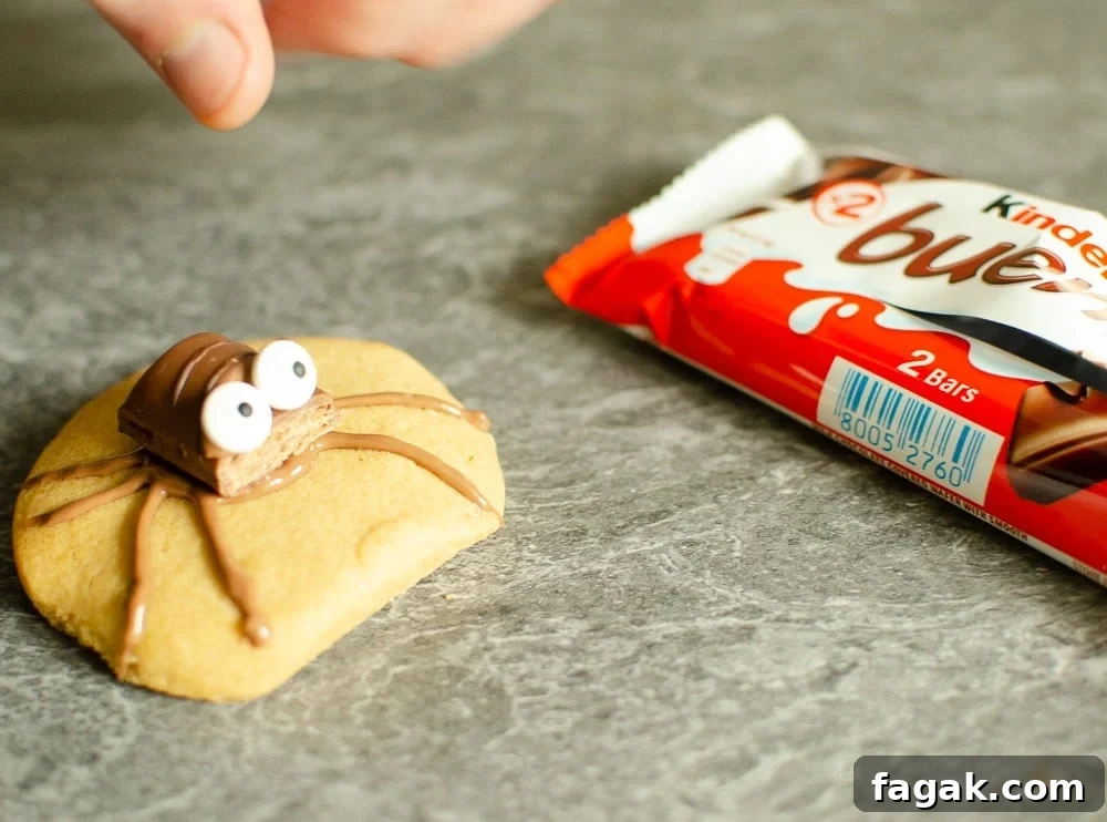 Cute Spider Halloween Biscuits on marble worktop with a Kinder Bueno chocolate bar on the side