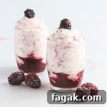 A fruit and cream dessert with blackberries.