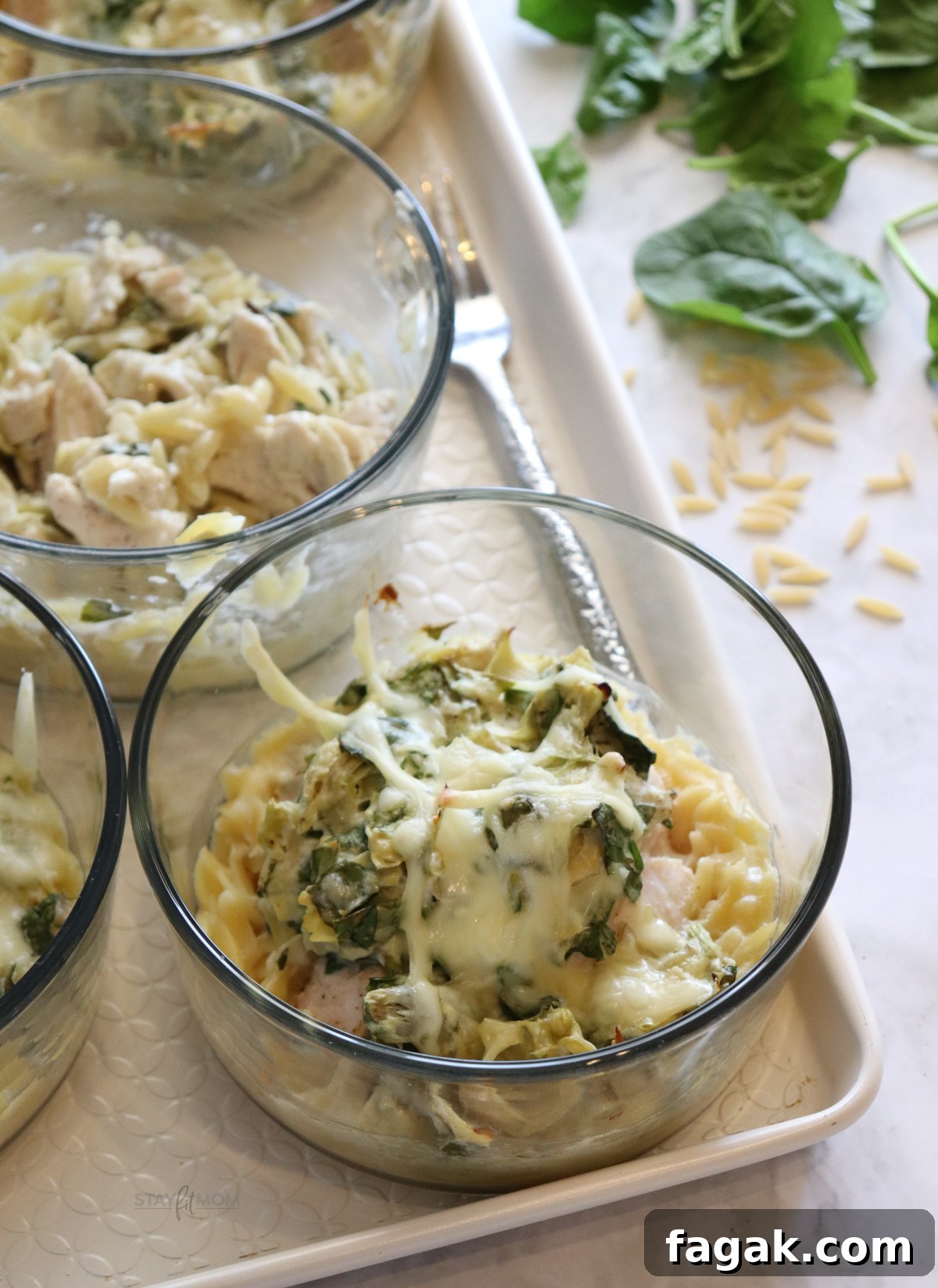 Spinach, Artichoke & Chicken Orzo Bake Recipe 3 Spinach Artichoke Chicken Orzo Bakes with visible chicken breast, orzo, spinach, artichoke hearts, and cheeses.