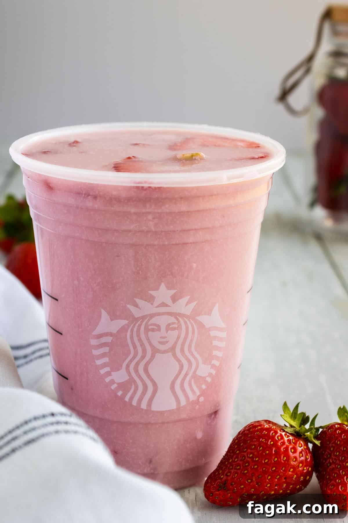 Glass of starbucks pink drink in a Starbucks cup.