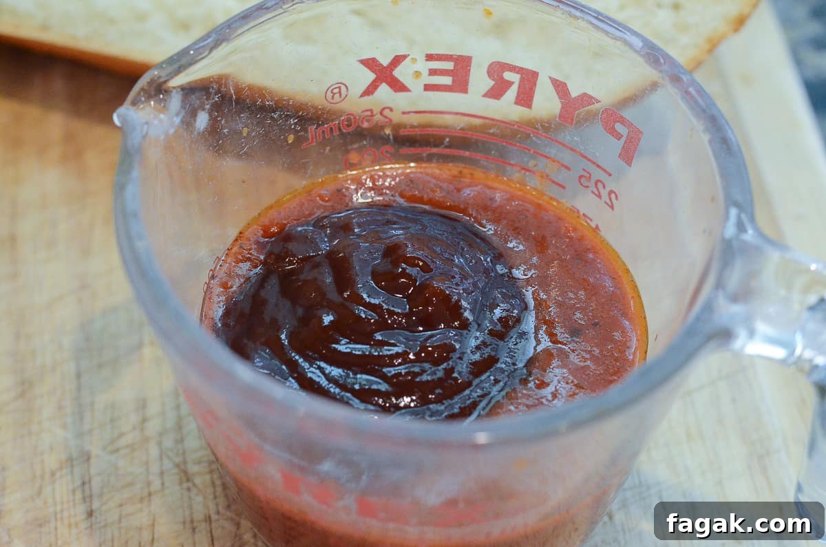 Marinara and BBQ sauce in a measuring cup.