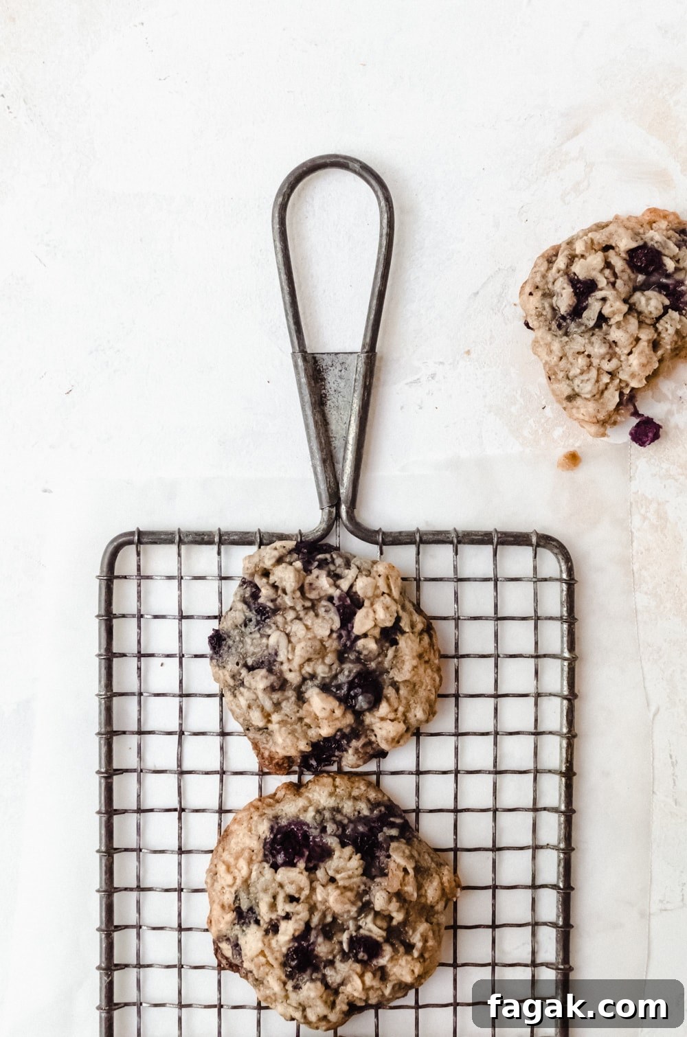 blueberry oatmeal cookies on wire rack with bite taken out