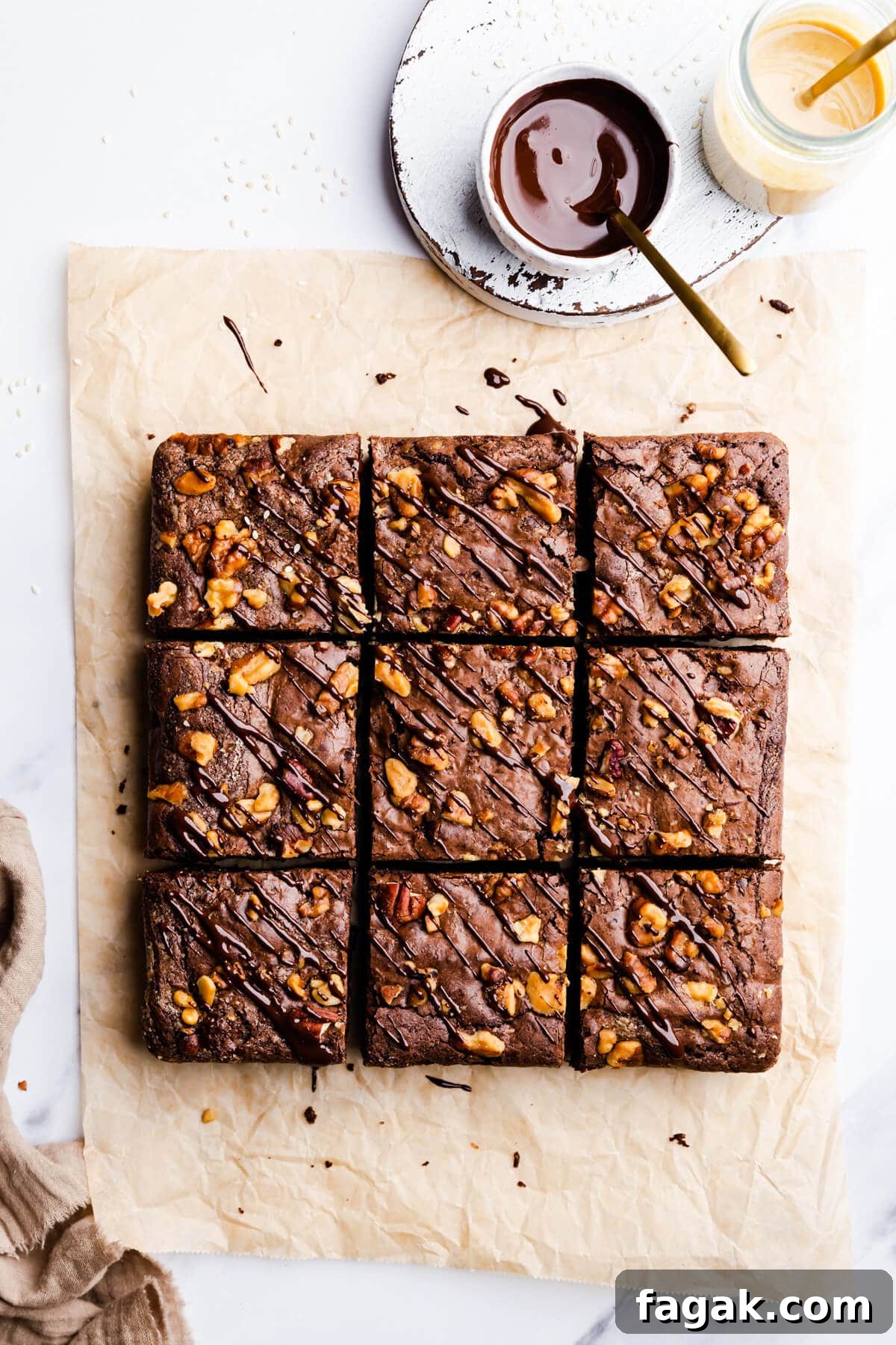 overhead view of 9 square slices of tahini and chocolate brownies with chocolate tahini drizzle