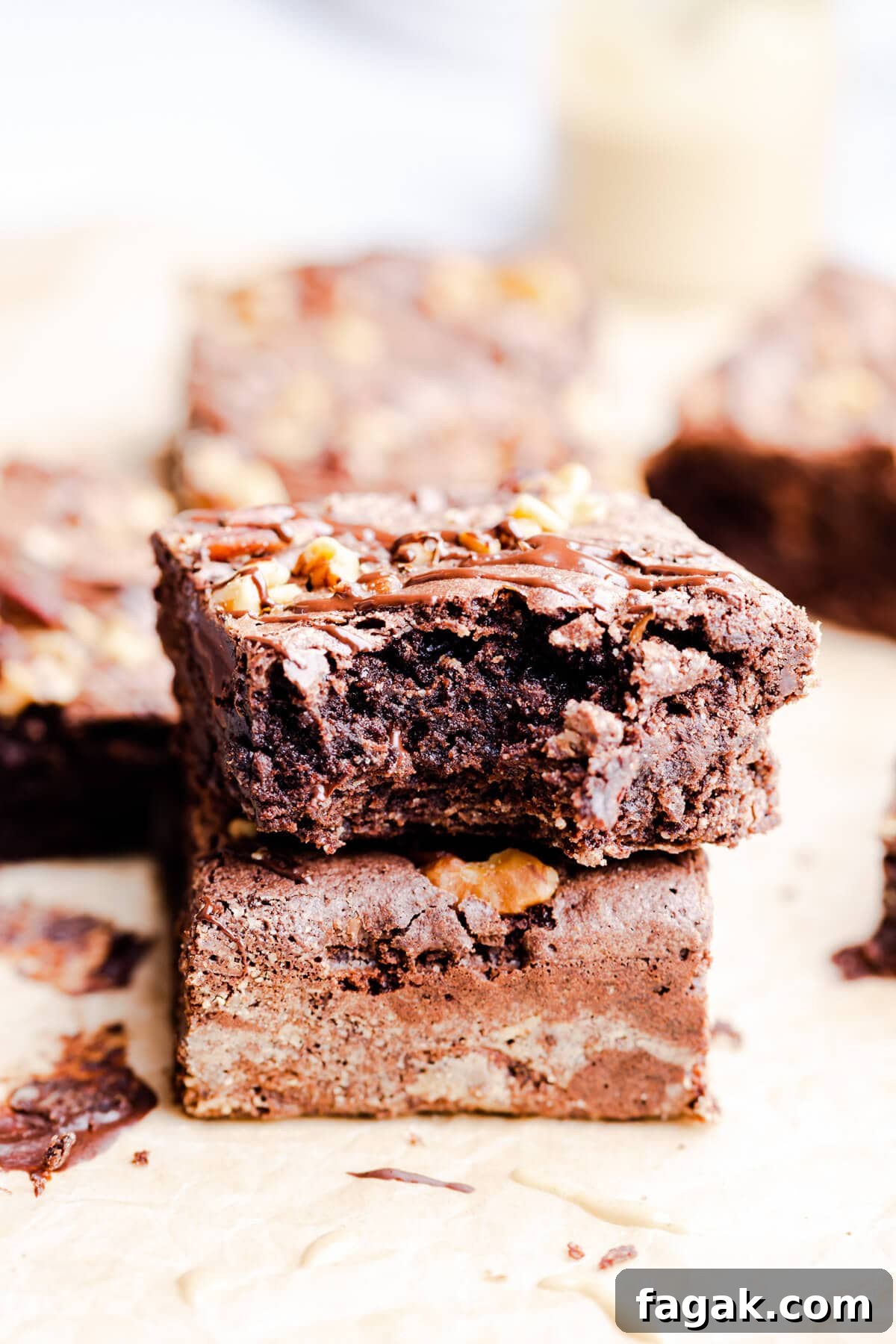 side close up of two chocolate brownies with one missing a bite