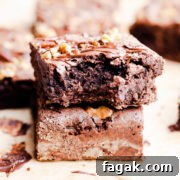 side super close up at a stack of two brownies with top one missing a bite.