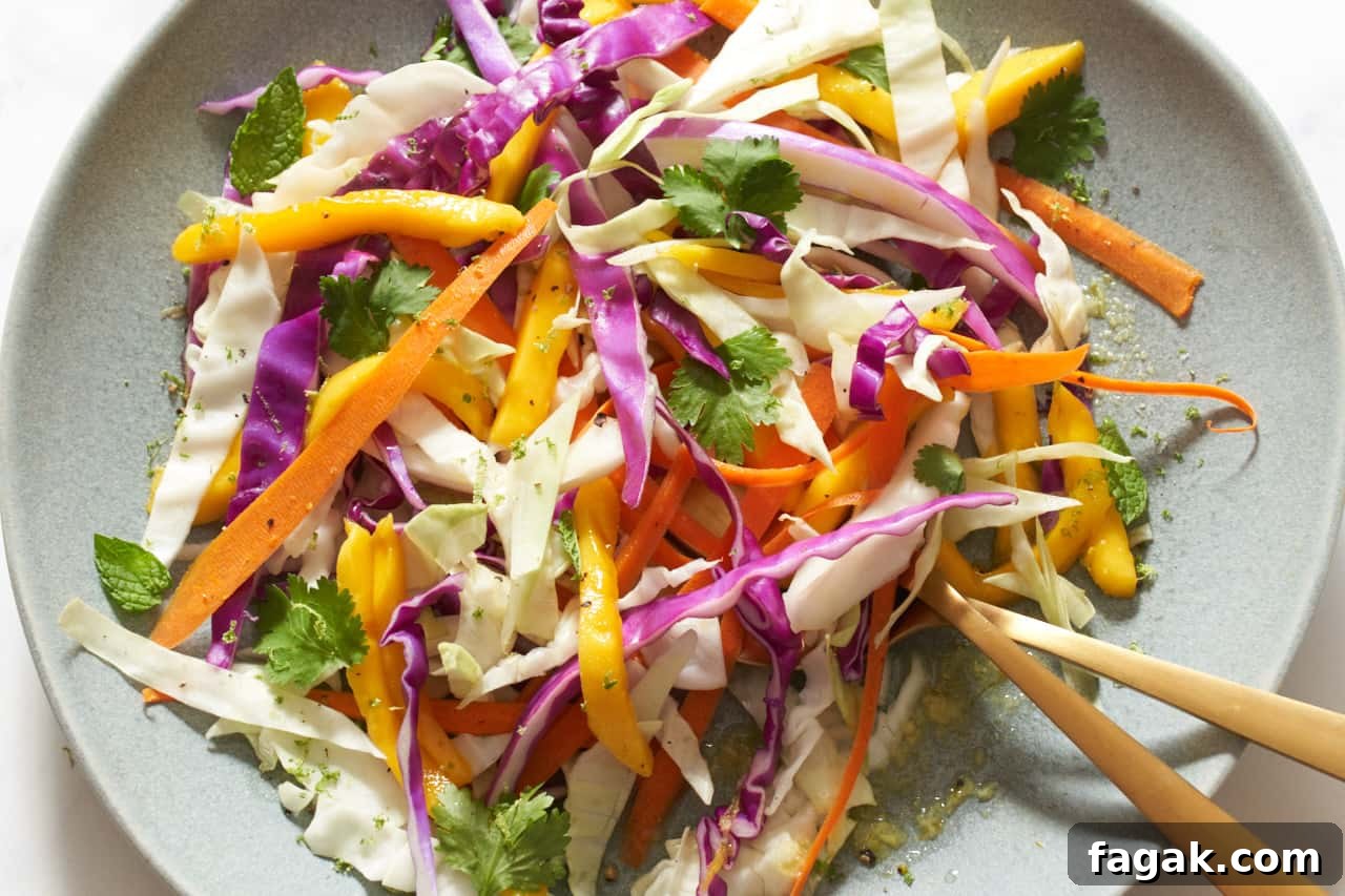 A plate of mango slaw with two gold utensils on it.