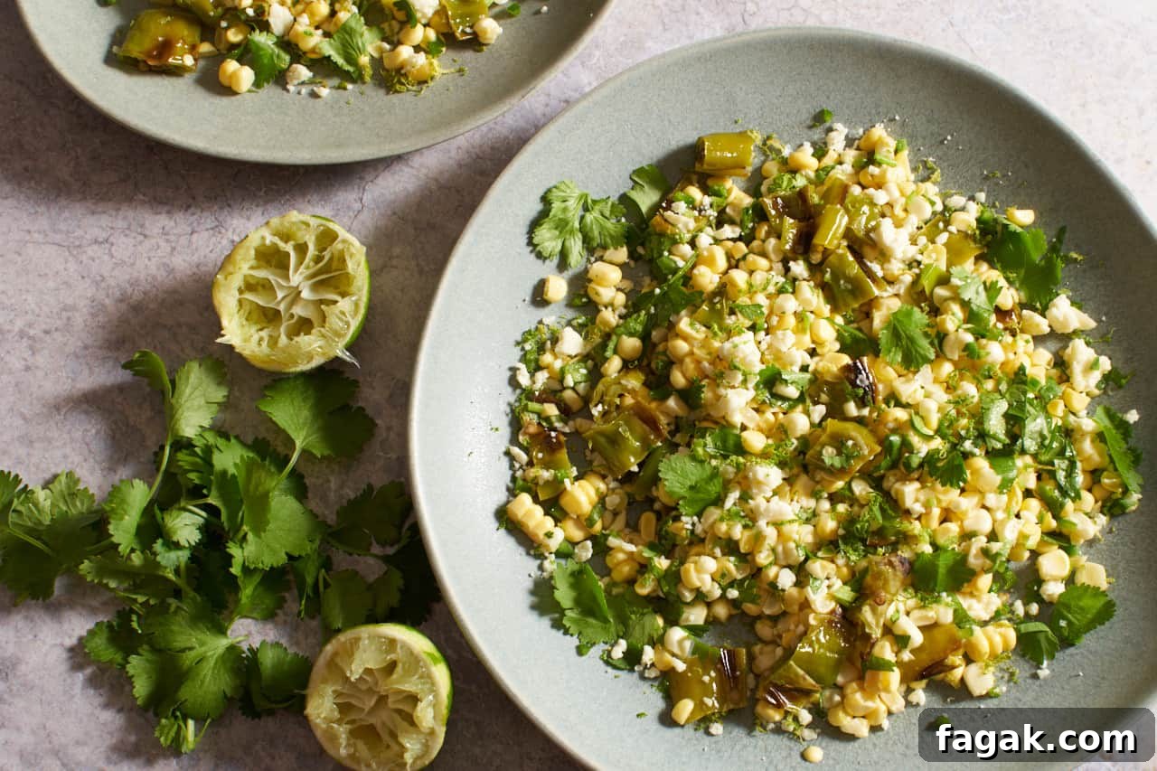Fresh corn salad on gray plates next to cilantro and squeezed limes.