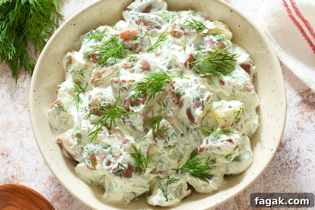 A bowl of dill potato salad topped with chopped fresh dill.