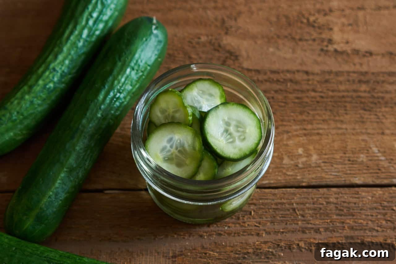 A small jar of quick pickles, two whole cucumbers are on the left.