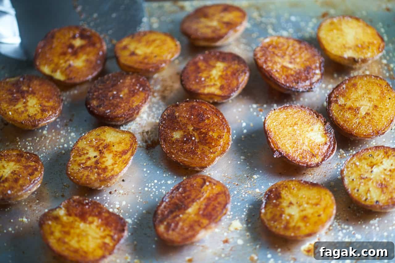 Crispy roasted potatoes seasoned with salt and pepper on a sheet tray.