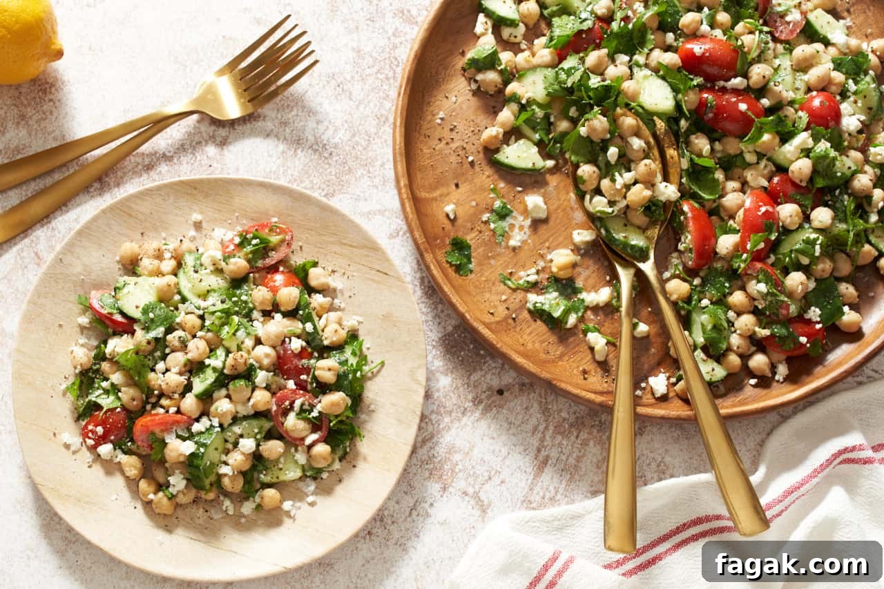 A large and a small wooden plate of garbanzo bean salad.