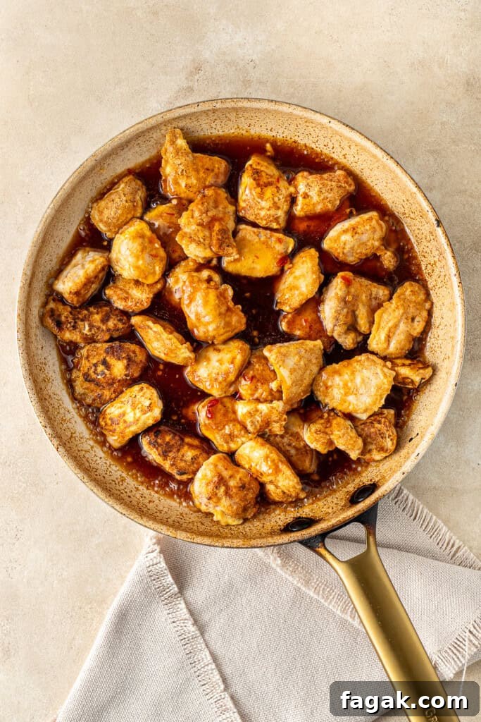 Adding the chicken and sauce to the frying pan.