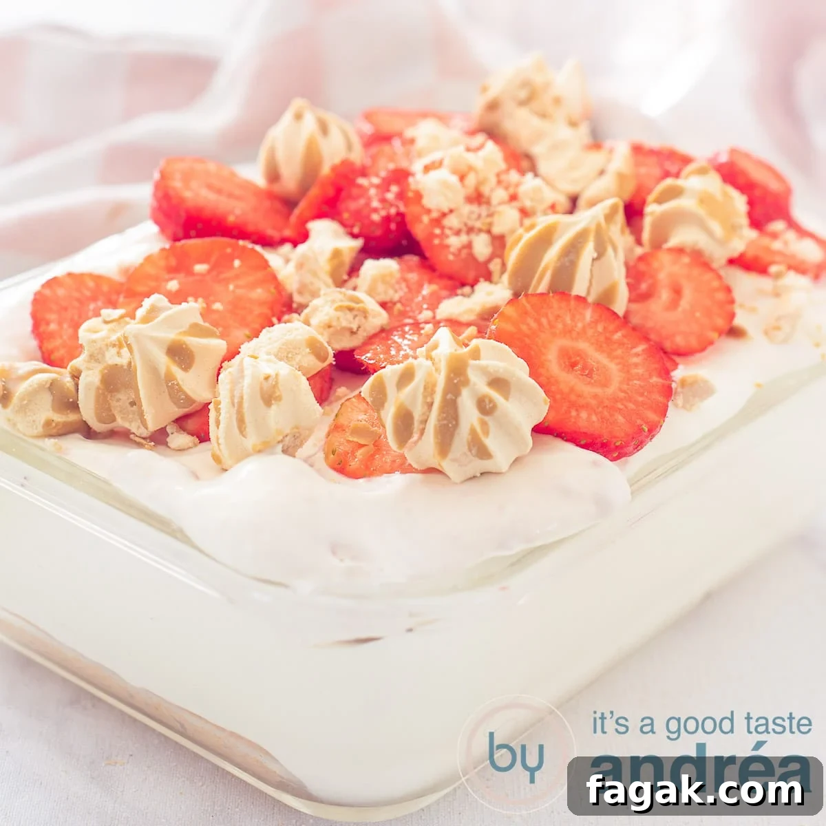 A square photo with a glass bowl filled with strawberry tiramisu on a white background