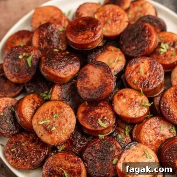A plate of cooked sausages with herbs on top.