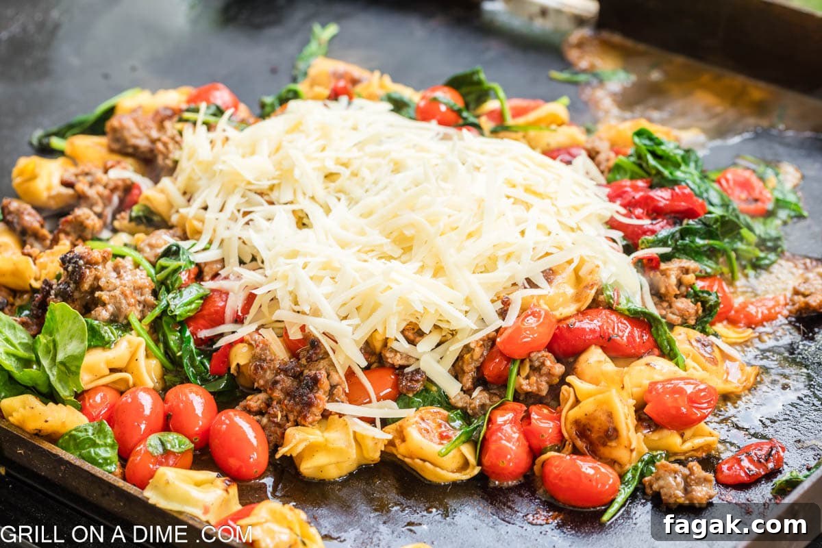 Shredded parmesan cheese on the cooked sausage, cherry tomatoes and fresh spinach