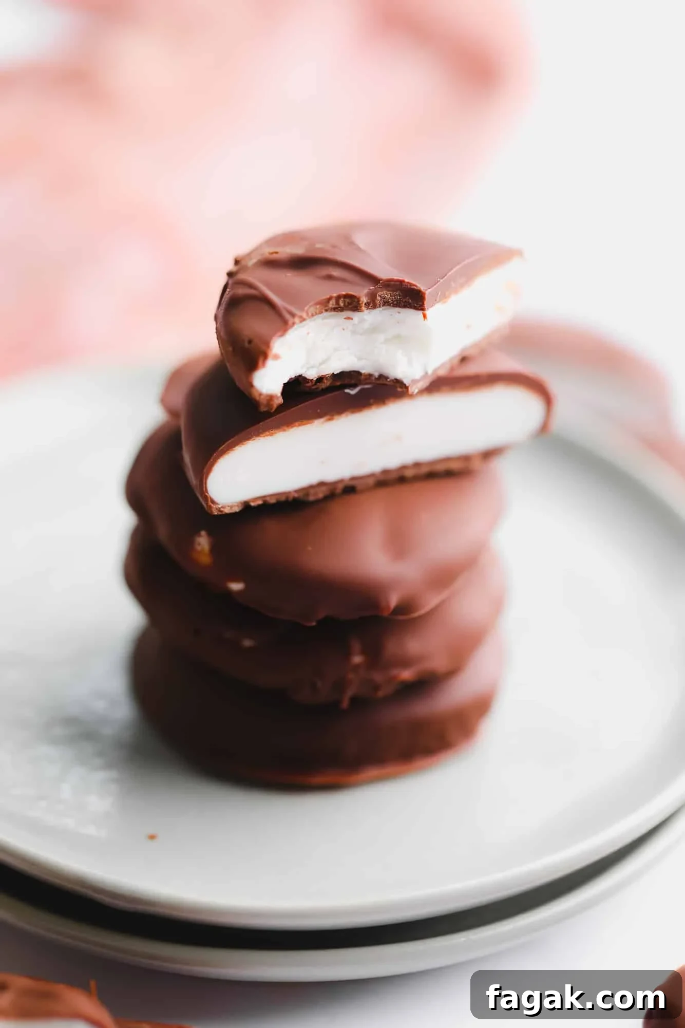 Vegan Peppermint Patties Recipe — Creamy Chocolate Mint Treats 2 a stack of vegan peppermint patties cut in half on a small plate.