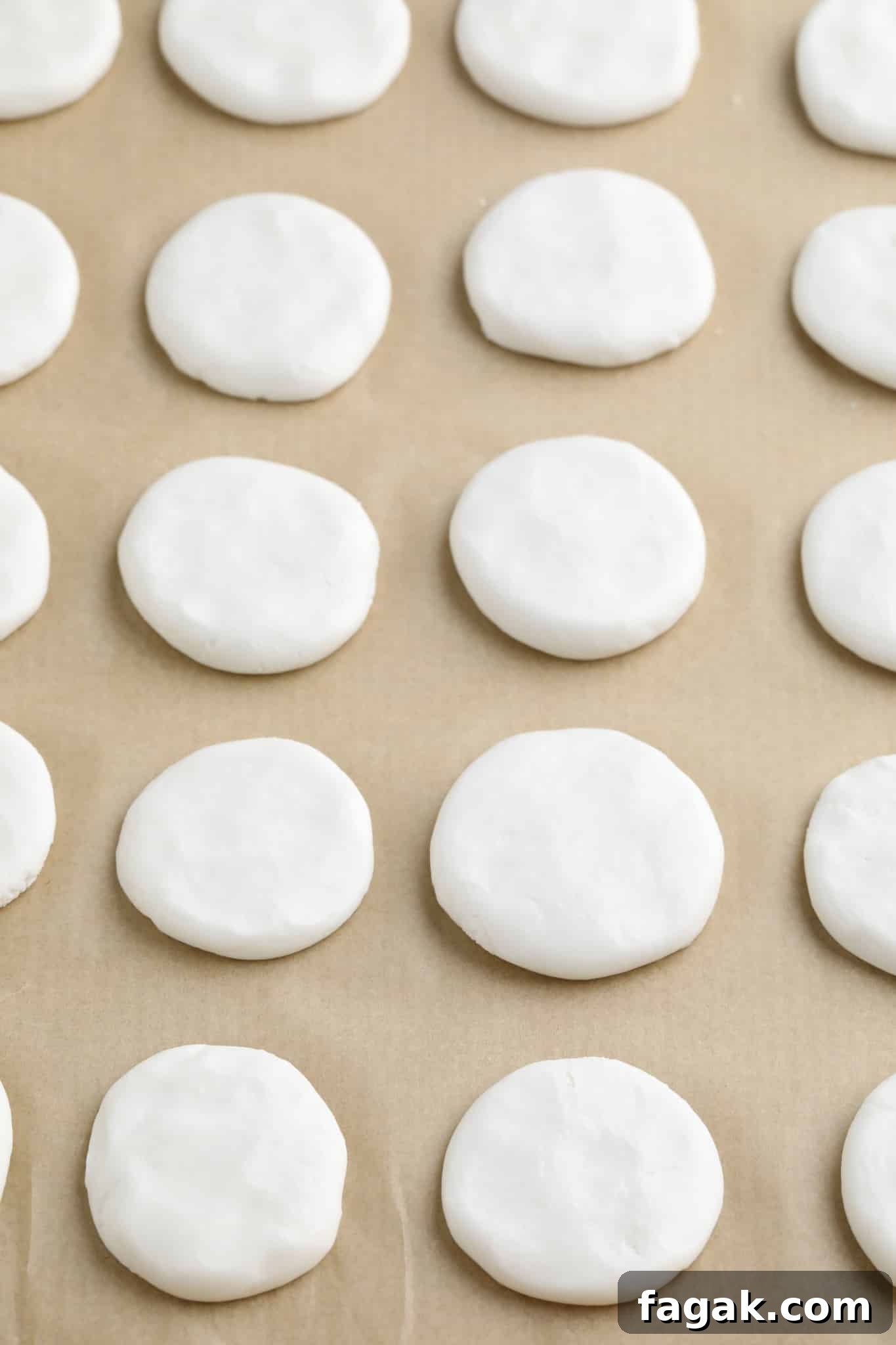 Vegan Peppermint Patties Recipe — Creamy Chocolate Mint Treats 5 white discs in rows on a parchment-lined baking sheet.