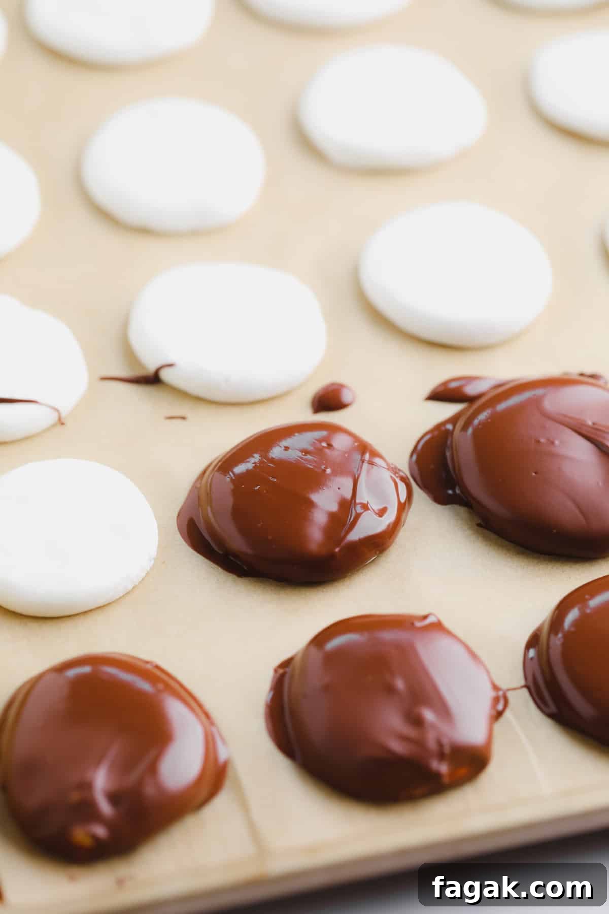 Vegan Peppermint Patties Recipe — Creamy Chocolate Mint Treats 6 chocolate-coated white peppermint discs on a parchment-lined baking sheet.