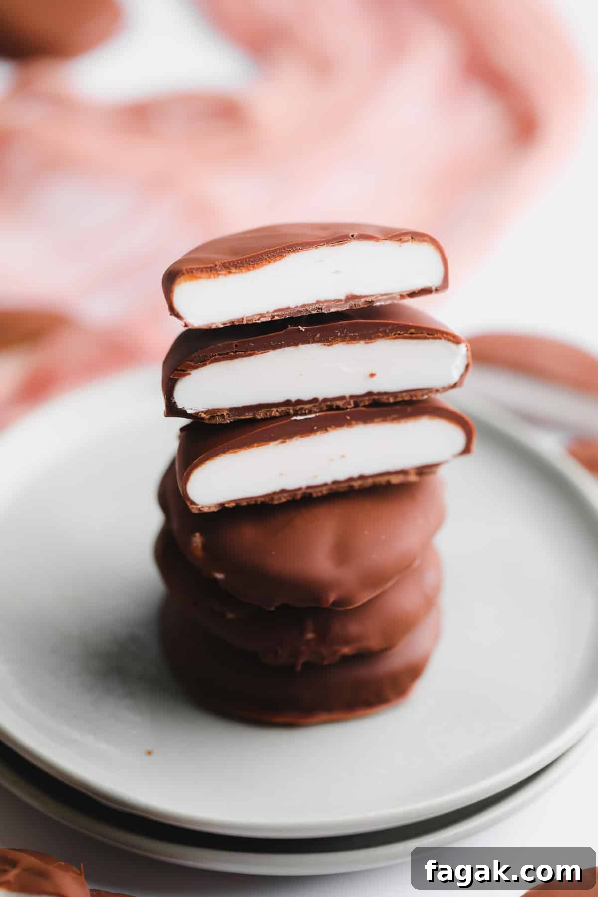 Vegan Peppermint Patties Recipe — Creamy Chocolate Mint Treats 7 a stack of vegan peppermint patties cut in half on a small plate.