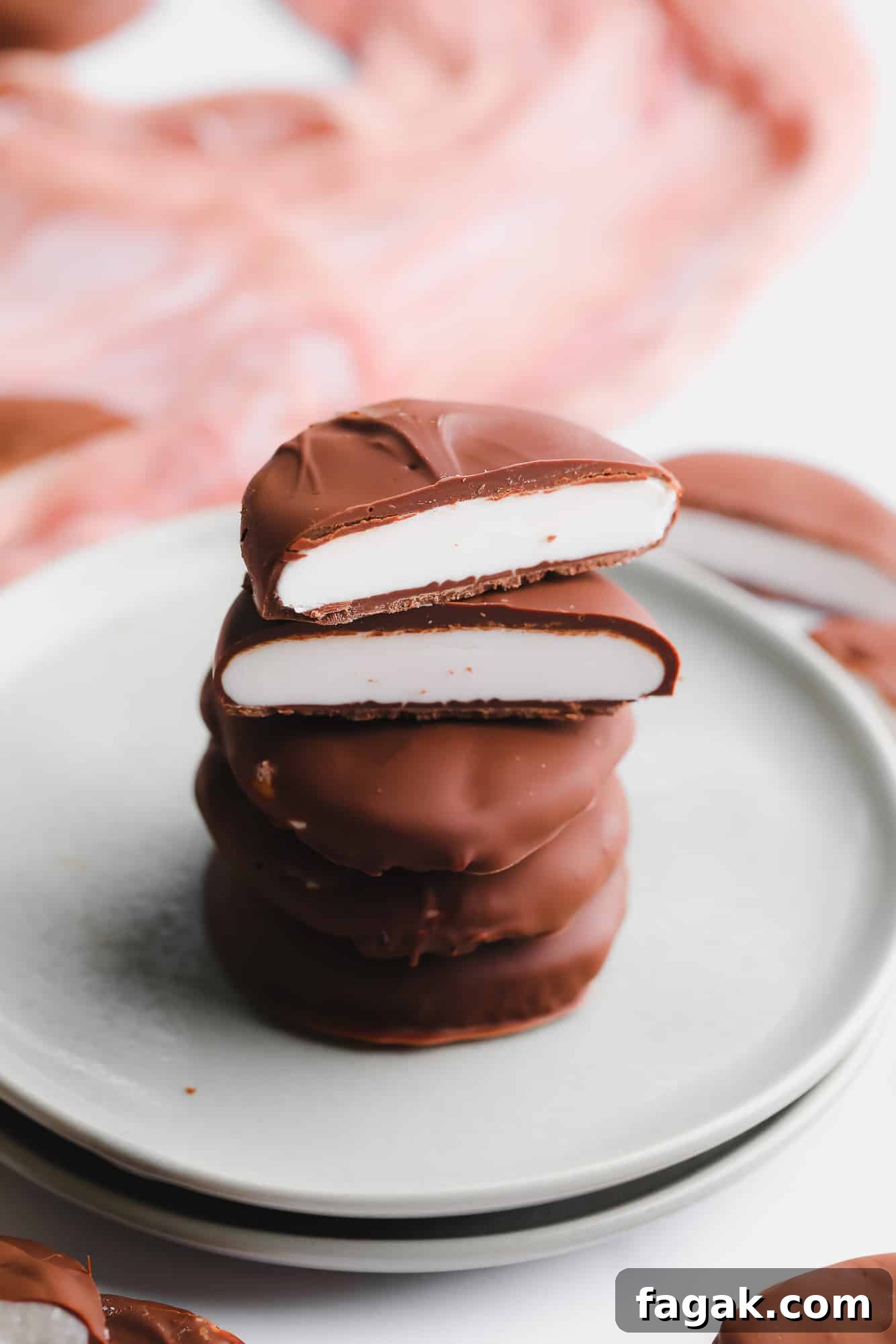 Vegan Peppermint Patties Recipe — Creamy Chocolate Mint Treats 8 a stack of vegan peppermint patties cut in half on a small plate.