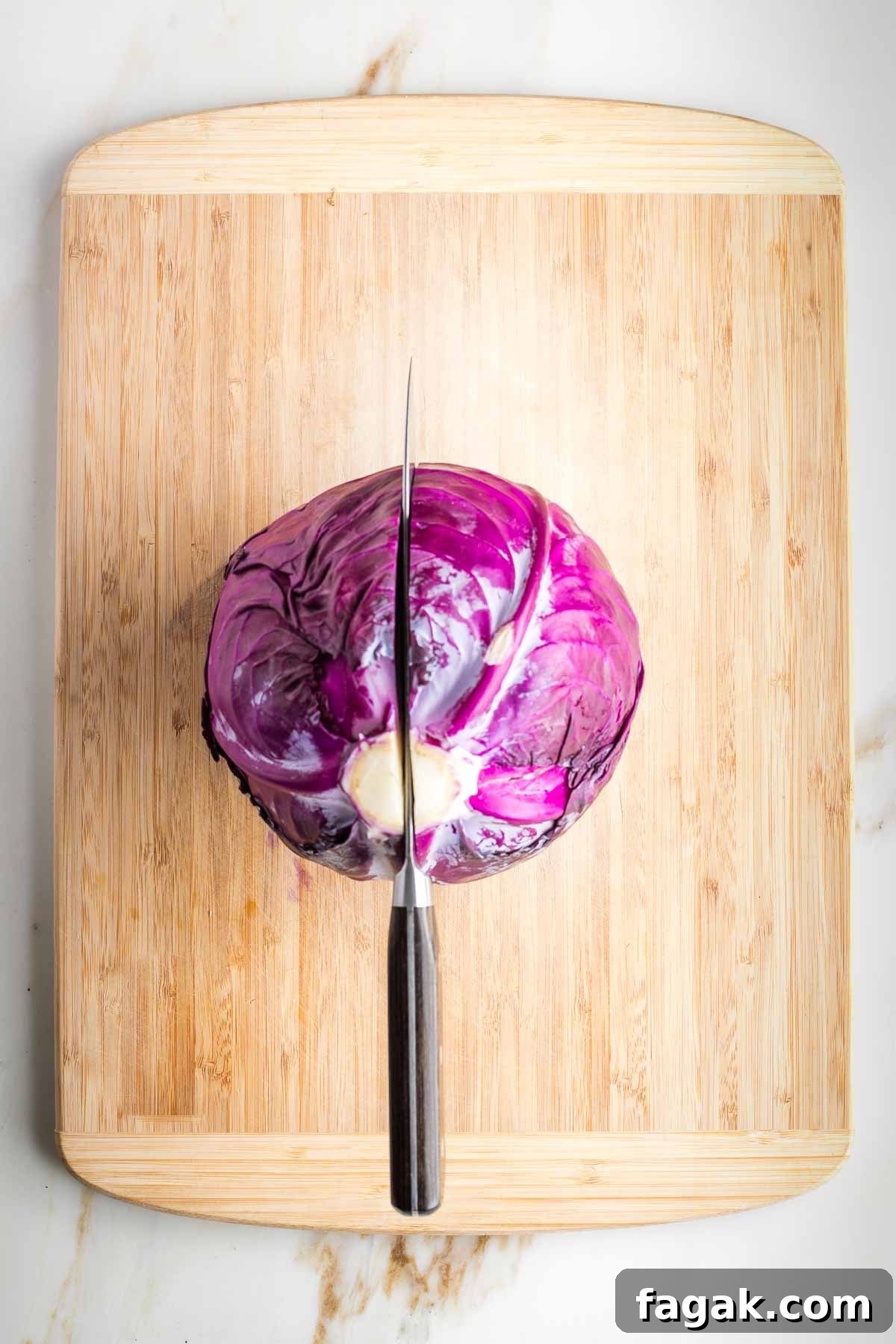 Crispy Oven-Roasted Red Cabbage with Balsamic Glaze 4 Halving a head of red cabbage, cutting through the core.