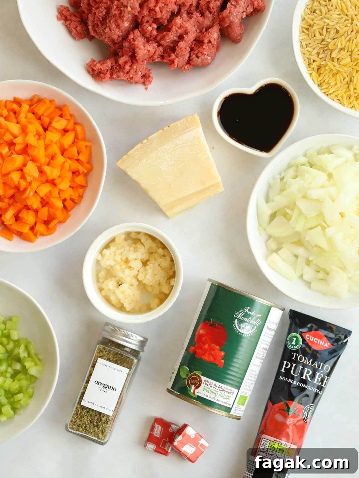 One-Pot Orzo Bolognese Recipe: Hearty Weeknight Dinner 4 Ingredients laid out on a counter top, including beef mince, tomatoes, onion, carrots, herbs and dried orzo pasta.